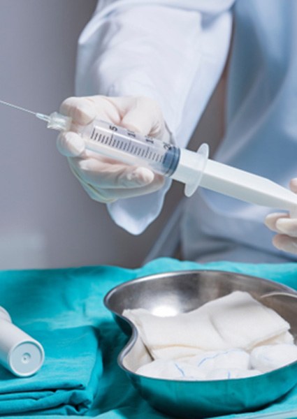 Doctor holding long needle used for amniotic fluid extraction