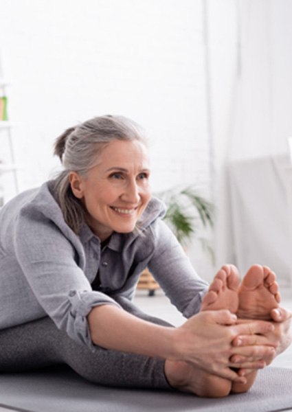 Mature woman smiling and stretching after amniotic growth factor treatment