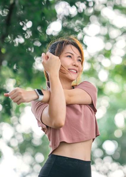 Smiling woman stretching her shoulder