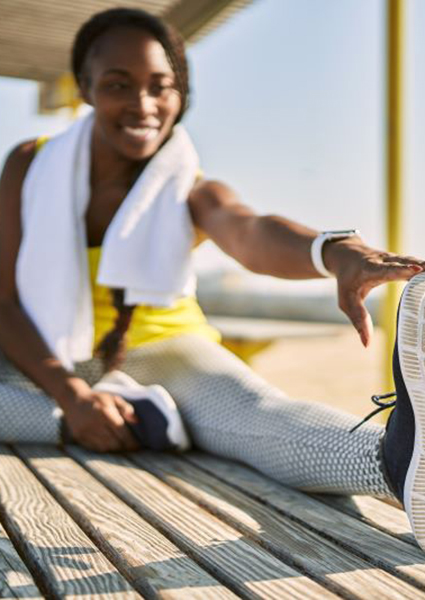 Smiling woman stretching after a workout