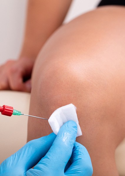 Close-up of patient’s knee receiving ozone injection