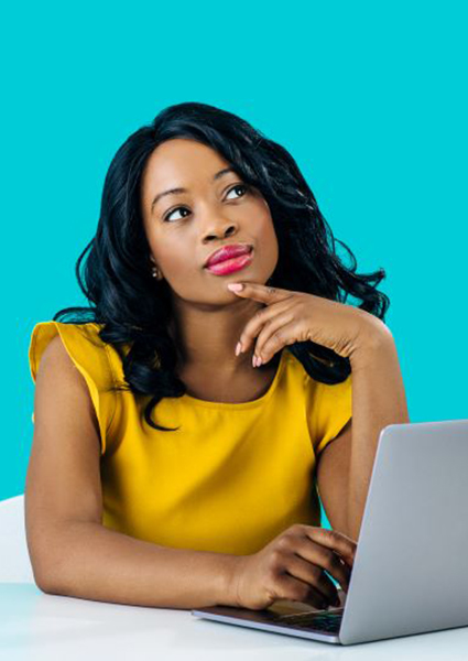 Woman sitting at computer, wearing curious expression