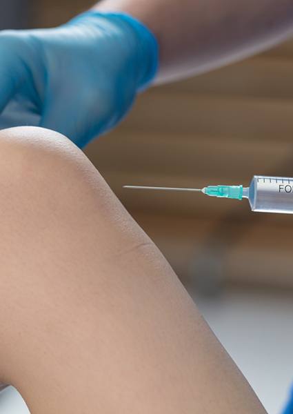 Doctor injecting solution into patient’s knee